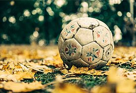abgenutzter Fußball auf Herbstblättern