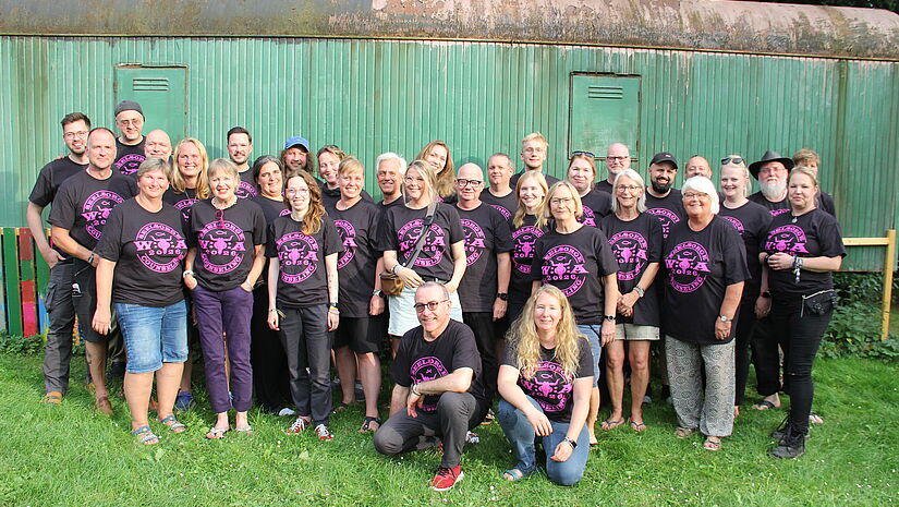 Ein Gruppe von Menschen in schwarzen T-Shirt mit pinkem Aufdruck. 