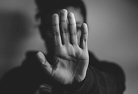 Frau zeigt "Stopp" mit Handfläche nach außen
