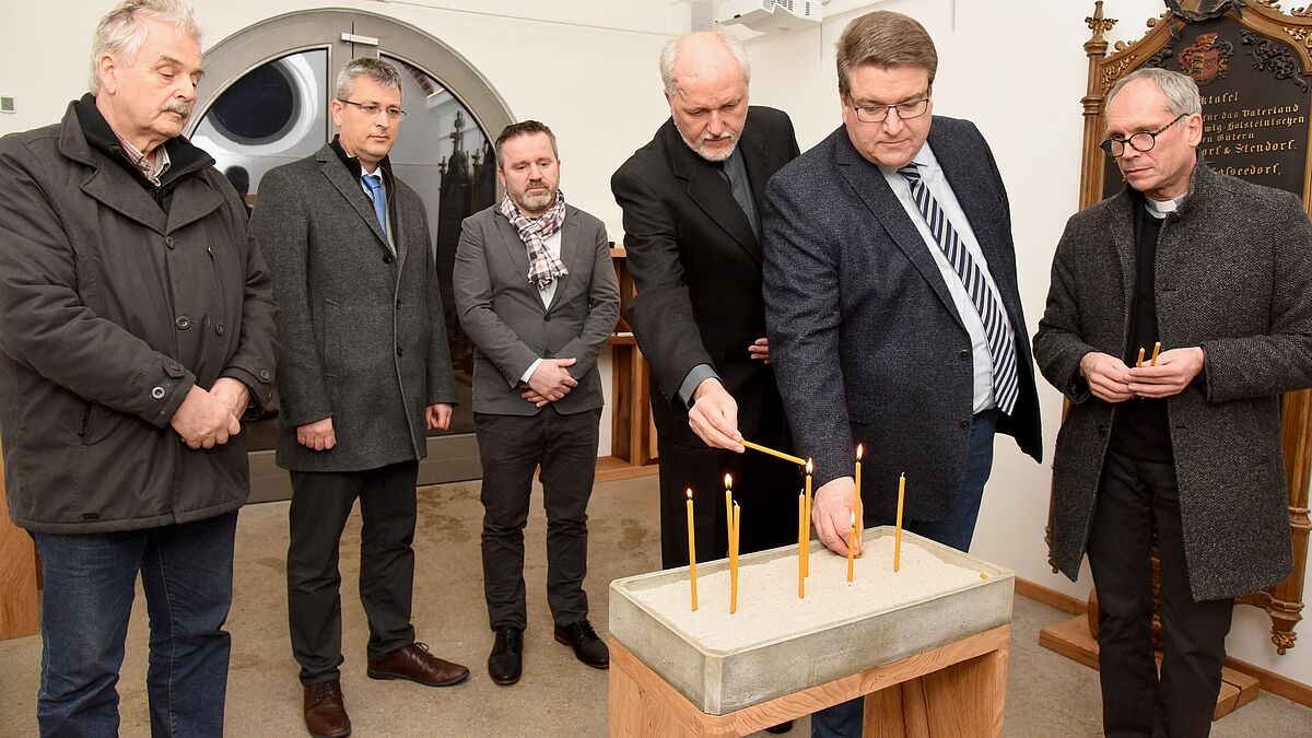 Gedenkkerzen für die Opfer von Hanau entzünden Pastor i.R. C. Huppenbauer (v.l.), Pastor S. Lorberg-Fehring, Abdulgafur Musliu, Pastor M. Hanfstängl, Propst D. Süssenbach, Pastor A. Heling.