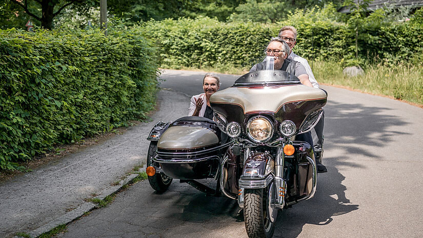 Bischöfin Kirsten Fehrs im Beiwagen und Initiator Steffen Schumann auf dem Sozius werden auf einer Harley Davidson gefahren