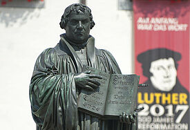 Denkmal des Reformators Martin Luther (1483 - 1546) mit der von ihm ins Deutsche übersetzten Bibel in der Hand auf dem Marktplatz der Lutherstadt Wittenberg.