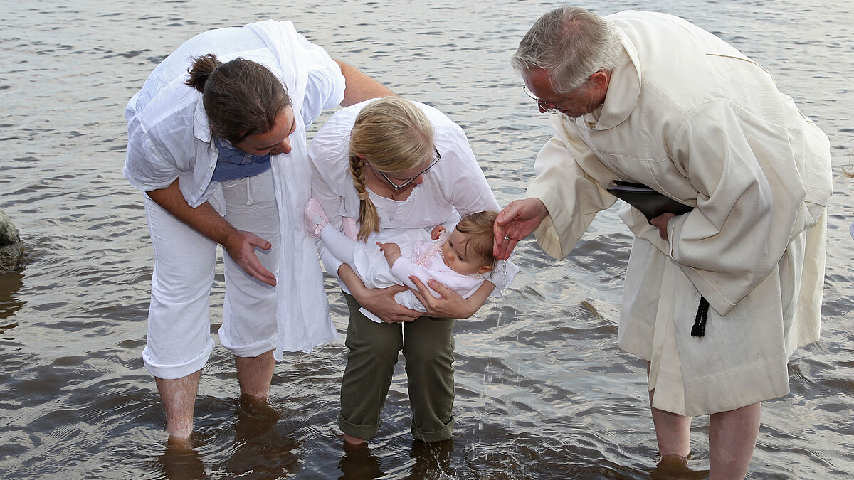 Am Hamburger Elbstrand wurden an Pfingstsamstag (11.06.2011) an 39 Taufstationen 243 Kinder getauft. Foto: Familie Heide und Daniel Diestel lassen Tochter Daliah von Pastor Bernd Neumann taufen. Bei strahlendem Sonnenschein wurde am "Falkensteiner Ufer" bei Blankenese das bislang größte Tauffeste der evangelischen Kirche gefeiert. Viele Pastoren tauften direkt im Wasser der Elbe, andere hatten eigenes Taufwasser mitgebracht. Das jüngste Kind war sechs Wochen alt. Unter den Täuflingen waren aber auch einige Jugendliche und Erwachsene. (Siehe epd-Bericht vom 12.06.2011)