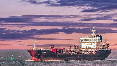 Containerschiff vor violettem Himmel 