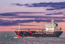 Containerschiff vor violettem Himmel 