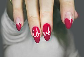Love-Schriftzug auf lackierten Nägeln