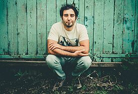 Sänger und Songwriter Artur Apinyan kommt mit seinem Klavier in die Autowerkstatt