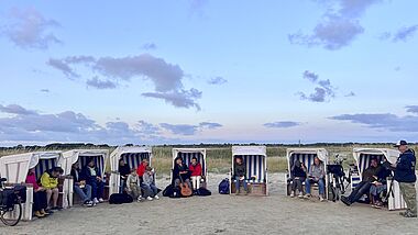 Sonnenuntergangsgedanken mit Gästen in Strandkörben