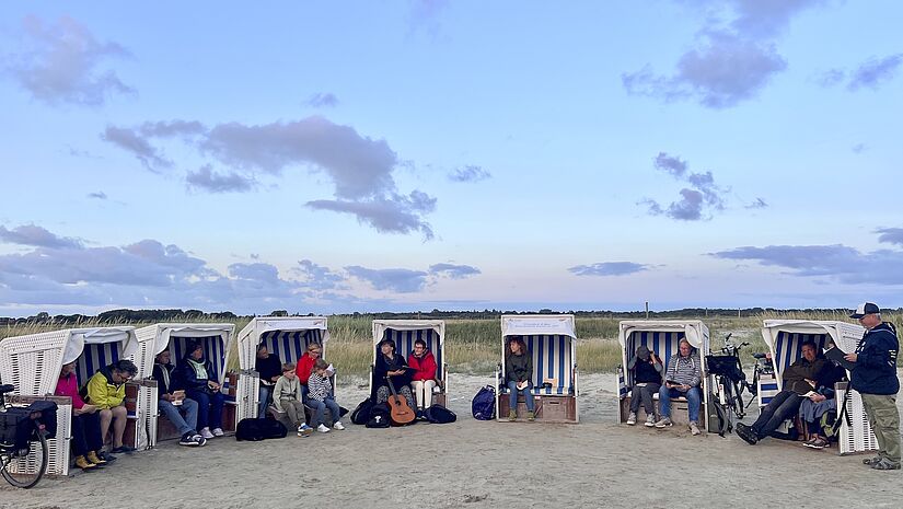 Sonnenuntergangsgedanken mit Gästen in Strandkörben