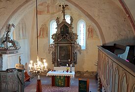 Heller Kircheninnenraum mit gotischen Bögen, links die Kanzel, rechts noch ein Stück der verzierten Empore