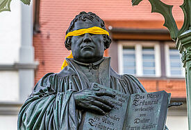 Luther mit Augenbinde: Als Abgrenzung und Protest zu Luthers Antisemitismus hat Friedrich Kramer dem Standbild von Martin Luther in Wittenberg eine gelbe Augenbinde angelegt.