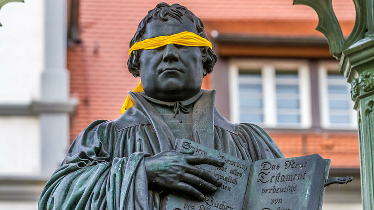 Luther mit Augenbinde: Als Abgrenzung und Protest zu Luthers Antisemitismus hat Friedrich Kramer dem Standbild von Martin Luther in Wittenberg eine gelbe Augenbinde angelegt.