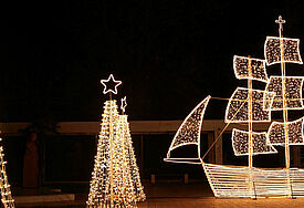 Segelboot und Weihnachtsbäume aus Lichterketten.