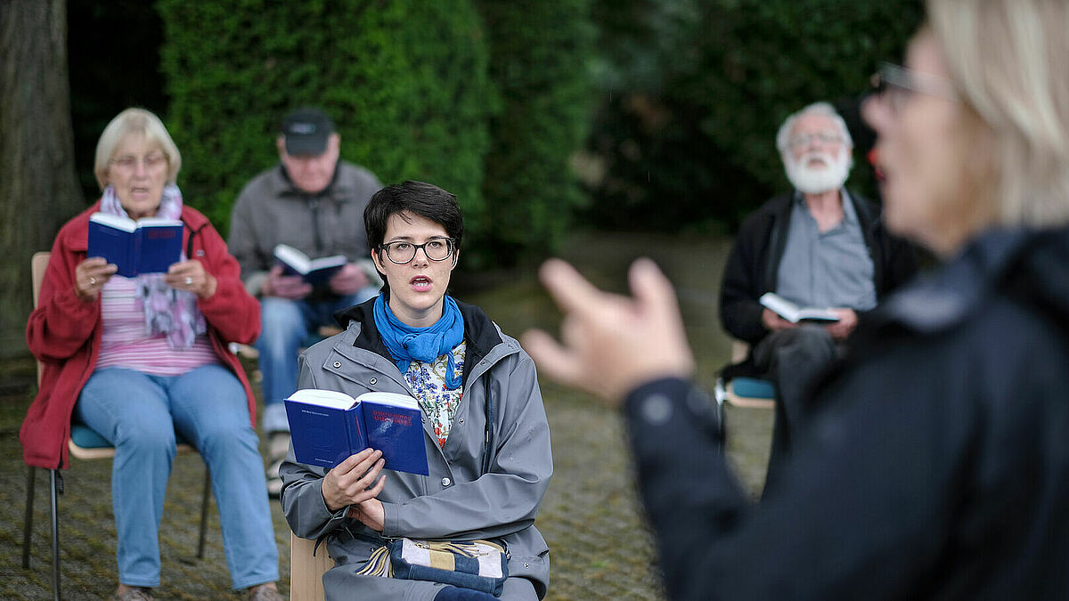 Chorprobe draußen und mit Abstand in einer Kirchengemeinde.