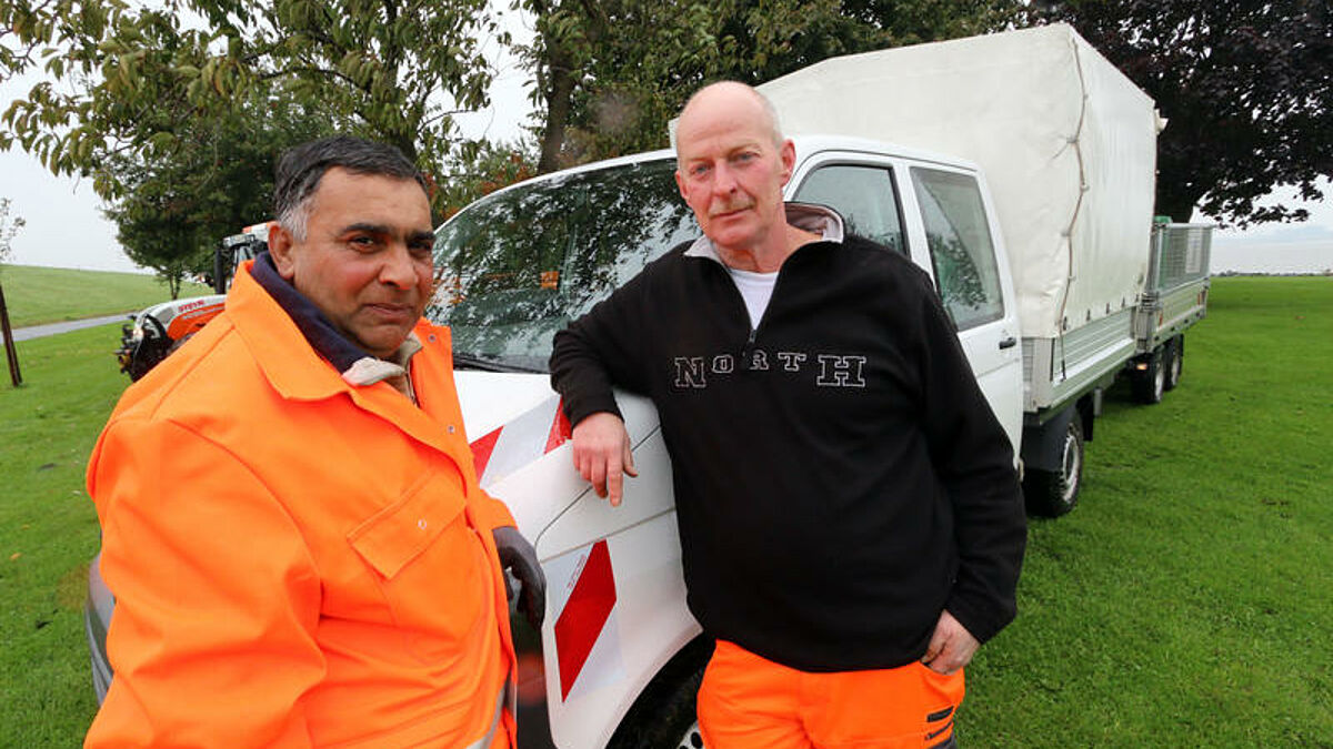 Adam Petric (50, links) und sein deutscher Kollege Gerd Gallas (54) vor ihrem Dienstwagen an der Lühe-Schulau-Fähre bei Steinkirchen im Alten Land. 