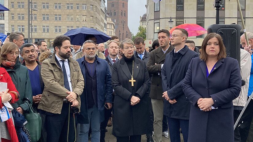 Die Landesbischöfin besucht die Kundgebung, um Solidarität mit den Opfern zu zeigen. Gleichzeitig mahnt sie zur Deeskalation der Lage. 