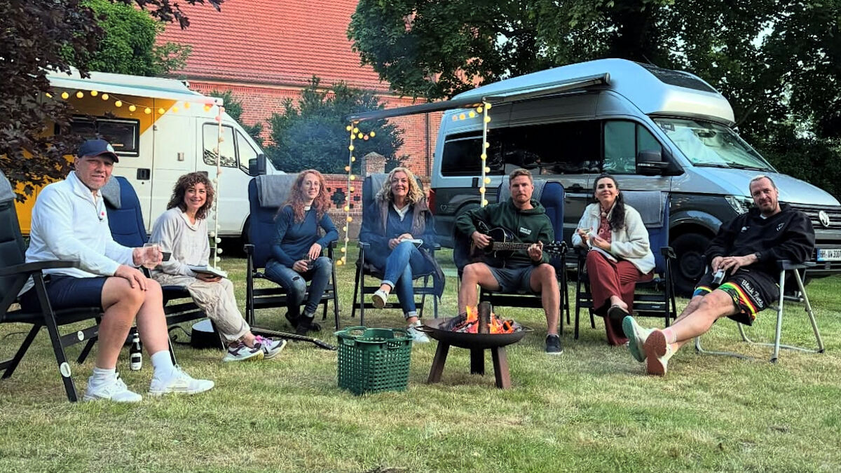 Die Moderatorin Bettina Tietjen (Mitte) machte mit ihrem Wohnmobil Station bei Pastorin Silke Kühn in Kartlow (3.v.li). Mit dabei waren die Promi-Camper und -Camperinnen Axel Schulz, Isabel Varell, Leo Reisinger, Ariana Baborie und Pascal Hens, genannt „Pommes“. Im Hintergrund die Kartlower Johanniskirche.