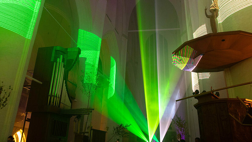 "Abstrait in der St. Katharinen Kirche" ist eine musikalische und visuelle Begegnung zwischen sakralen und meditativen Klängen und Beats, Klassischer Musik, Ambient und Downtempo, die von farbigen Lichtern und Lasern begleitet werden. Grüne Laserlichter strahlen in der St. Katharinen-Kirche.