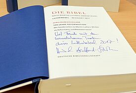 Aufgeschlagene Lutherbibel vor zwei senkrecht stehenden Exemplaren