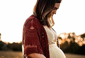 Schwangere junge Frau hält ihren Bauch