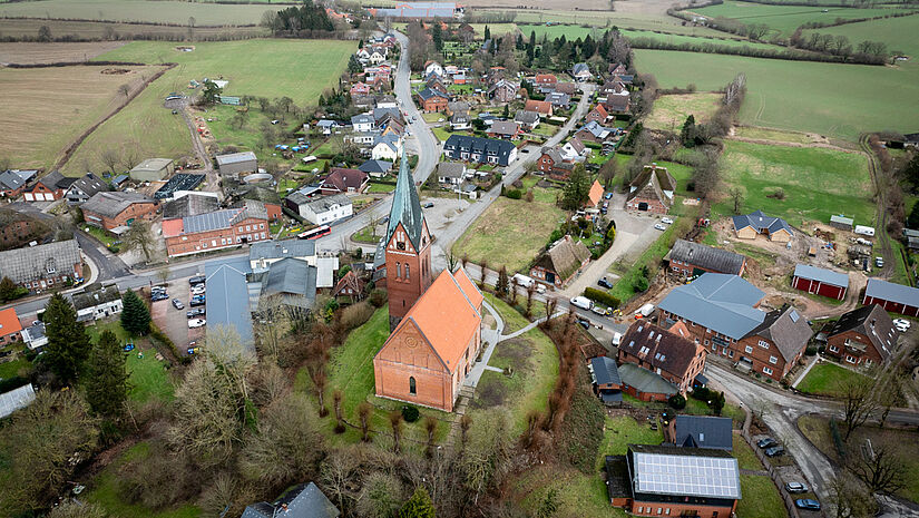 Die Gemeinde Sandesneben mit Kirche und Kirchberg aus der Luft. 