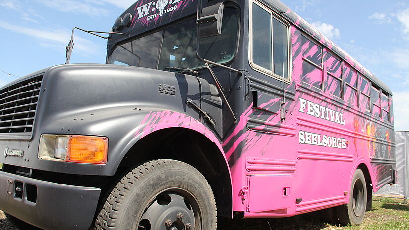 Ein alter US-Schulbus in pinker und schwarzer Lackierung