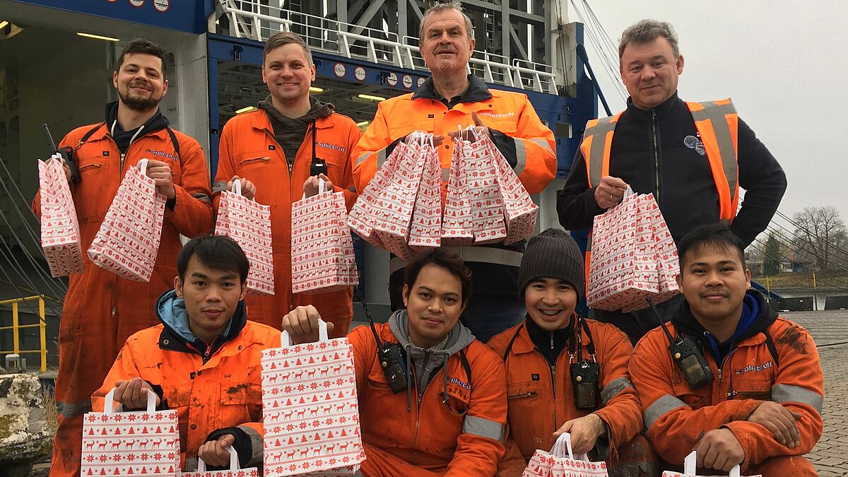 Große Freude bei Kapitän Jan Hoek (3.v.links, hintere Reihe) und seiner Mannschaft: Die Deutsche Seemannsmission der Hansestadt Lübeck bringt Geschenke an Bord der "Grenca". 