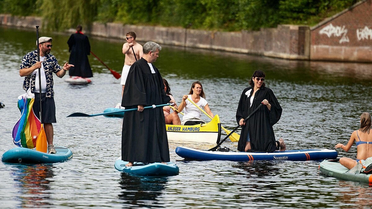 Pastorinnen und Pastoren der Pop Up Church unterwegs auf Stand Up Boards auf der Alster.