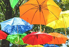 Bunte Regenschirme hängen als Deko in der Luft