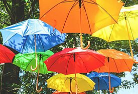 Bunte Regenschirme hängen als Deko in der Luft