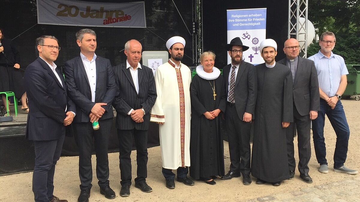 Dr. Farjad Yazhari (v.l.), Dede Mahsuni Ime, Rolf Peters, Imam Orhan Celik, Bischöfin Kirsten Fehrs, Rabbiner Shmuel Havlin, Hojjat-ul-Islam Esmaeil Ansari, Pater Richard Nennstiel, Nils Clausen gestalteten das Friedensgebet auf der Altonale.