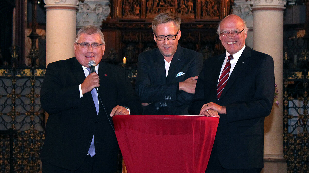 Landtagspräsident Klaus Schlie (links) und Landesbischofs Gerhard Ulrich (rechts) mit Moderator Jan Malte Andresen