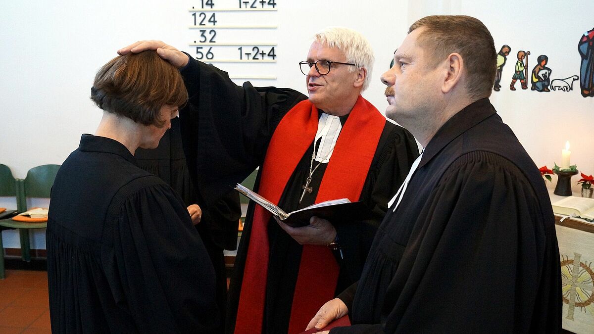 Pastorin Inke Pötter wird durch Propst Andreas Haerter (Mitte) und Pastor Matthias Bartels der Segen zugesprochen