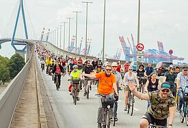 Radfahrer rollen die Köhlbrandbrücke entlang.