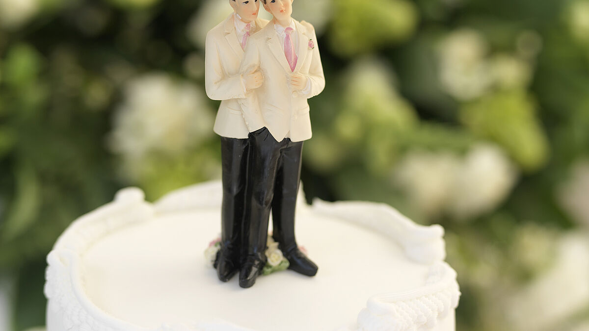 Figurines, depicting a gay wedding or Civil Partnership, on top of a wedding cake, narrow focus on the head.