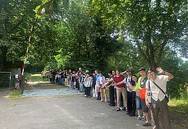 Die Gruppe bildet eine Menschenkette über die deutsch-dänische Grenze.