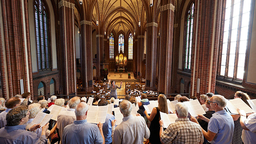 Landeskantorin Christiane Hrasky dirigiert den Chor beim musikalischen Festgottesdienst in der Schweriner Paulskirche.