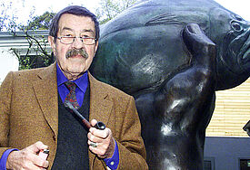 Günter Grass im Oktober 2002 vor dem "Günter-Grass-Haus" in Lübeck. Im Hintergrund die Skulptur "Der Butt im Griff – große Fassung"