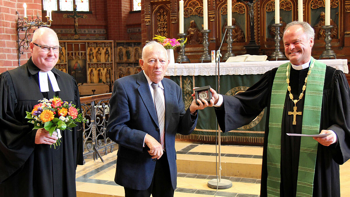Bischof Tilman Jeremias (rechts) zeichnet Gerhard Meyer mit der Bugenhagen-Medaille aus. Herzliche Glückwünsche an den Parchimer überbrachte Propst Dirk Sauermann im Namen des Kirchenkreises Mecklenburg. 