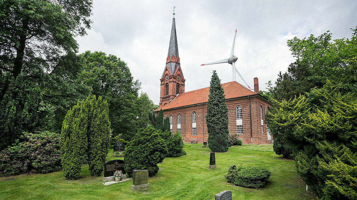 Liegt in einem Tal, umgeben von Windrädern: Die Kirche St. Gertrud im Hamburger Hafen.