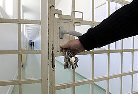 Ein Wärter verschließt eine Tür im Gefängnis