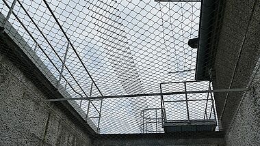 Blick in den vergitterten Himmel im Gefängnis 