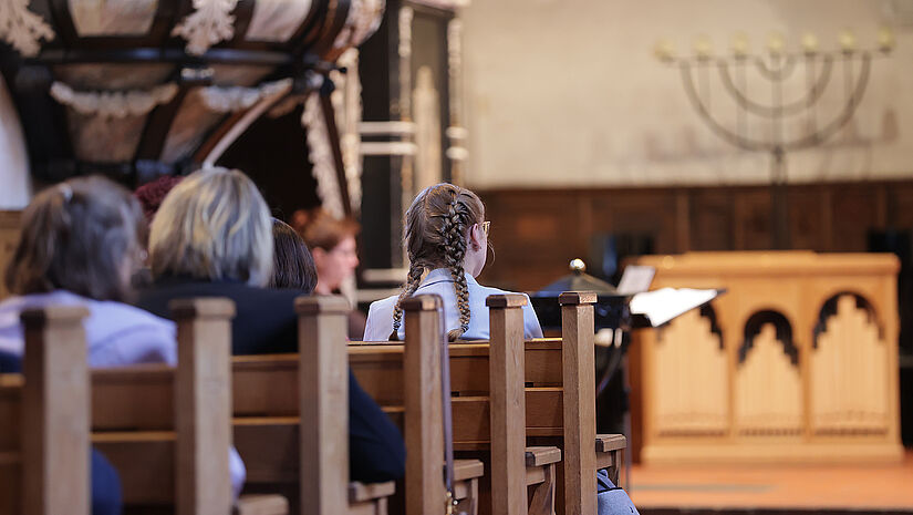 Gottesdienstbesucher:innen auf den Kirchenbänken in St. Lorenz