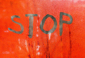 Beschlagenes Schild, auf das jemand mit den Fingern Stop geschrieben hat