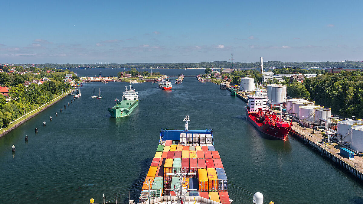 Ein Containerfrachtschiff nähert sich den Schleusen des Nord-Ostsee-Kanals bei Holtenau. Hier gehen auch die Mitarbeitenden der Seemannsmission Kiel an Bord der Schiffe. 20 Minuten haben sie dann Zeit.