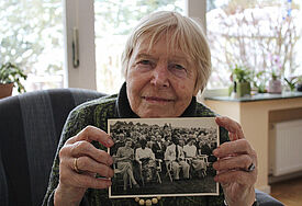 Donate Linck (84) hält in ihrer Wohnung in Ahrensburg bei Hamburg ein Foto vom Kirchentag 1953 in den Händen, bei dem sie als 25-jährige Studentin (links im Foto) für einen afrikanischen Minister ins Englische dolmetschte.