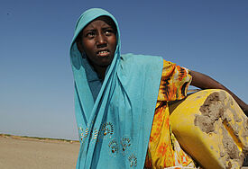 Eine Frau in der Steppe mit Wasserkanister. © Christof Krackhardt/Brot für die Welt