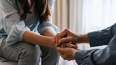 Junge Frau hält die Hand eines Mannes