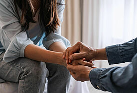 Junge Frau hält die Hand eines Mannes