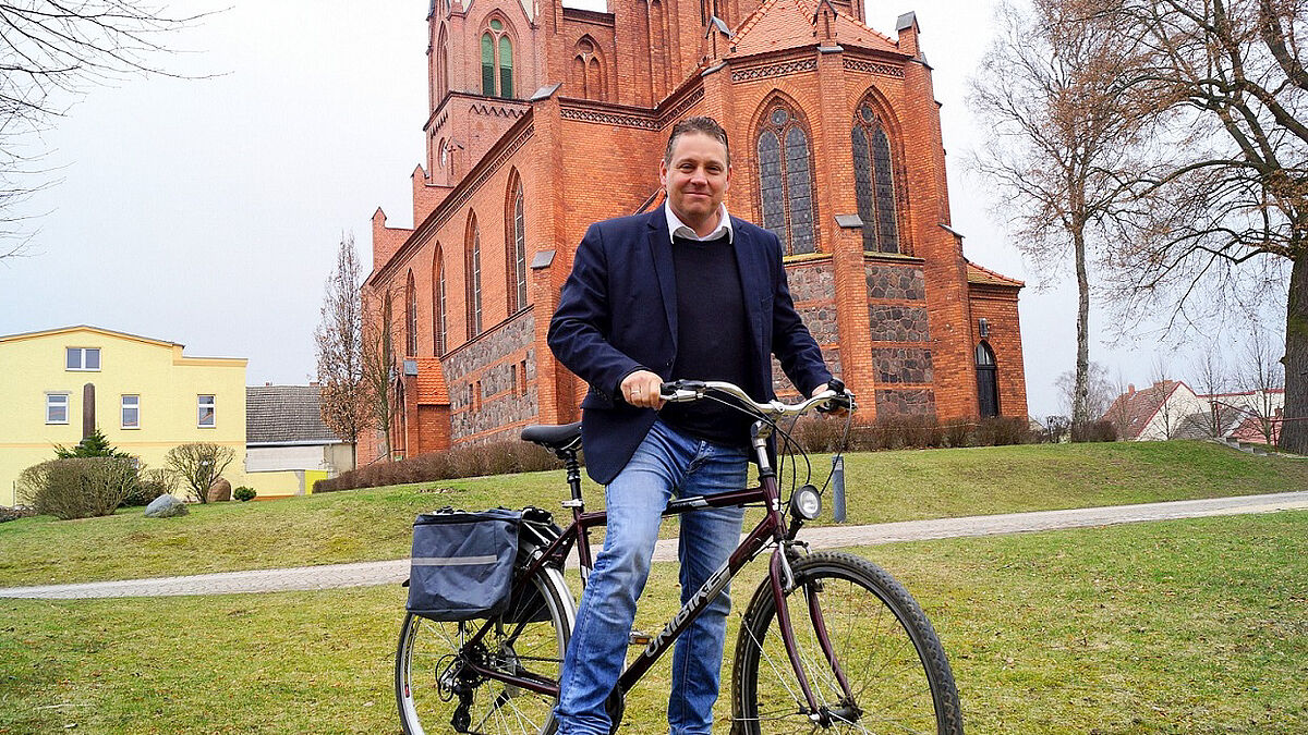 Pastor Bernhard Riedel vor der Kirche in Penkun: Er ist schon im Training für die große Radtour kommenden August.